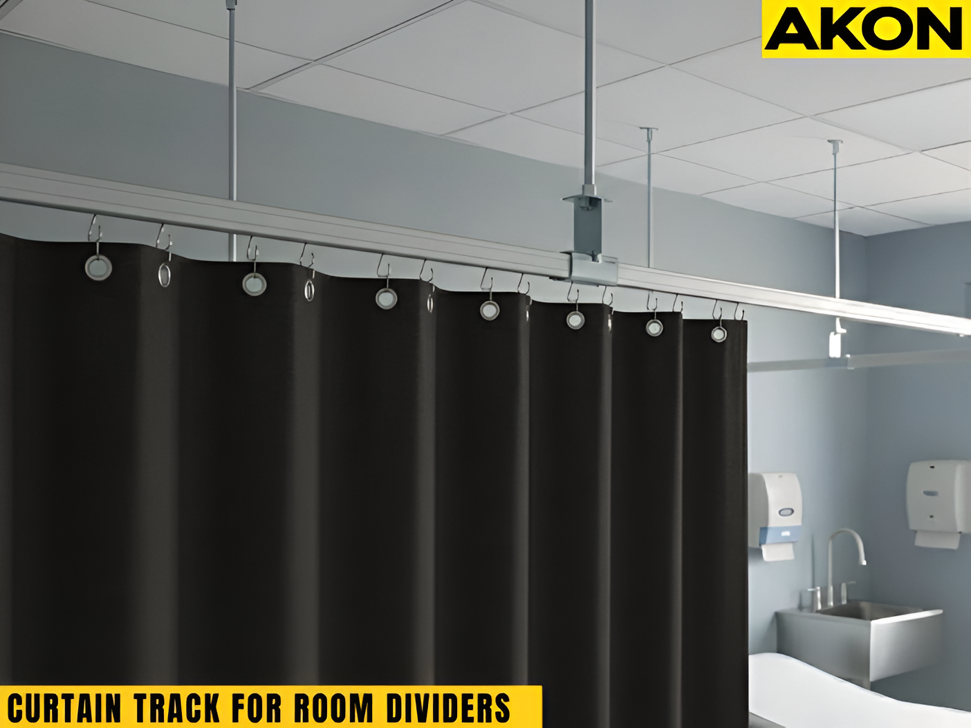 Black privacy curtain on ceiling-mounted curtain track dividing a commercial restroom space.