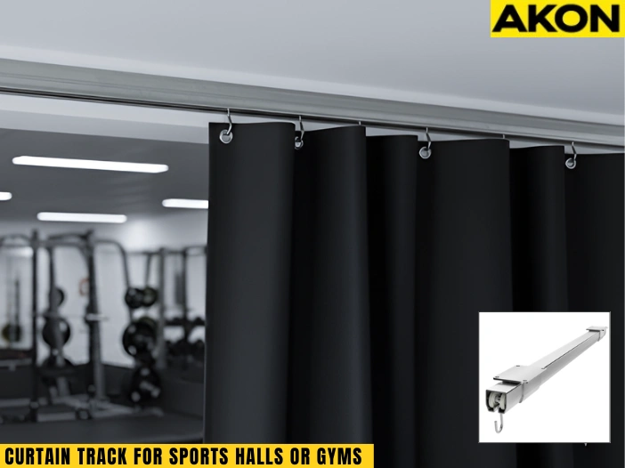 Ceiling-mounted curtain track dividing a sports hall gym with black divider curtain