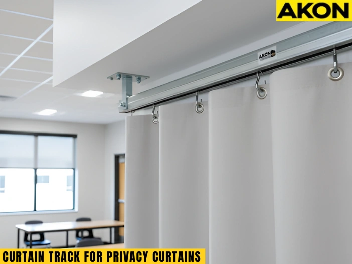 Ceiling-mounted curtain track supporting privacy curtains in a classroom space