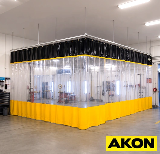 Durable curtain track system installed in an industrial paint booth to divide and control spray zones.