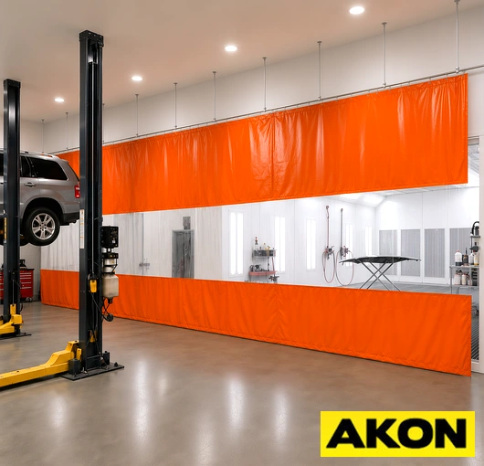 Industrial curtain track system installed in a paint booth to separate work zones and control overspray.