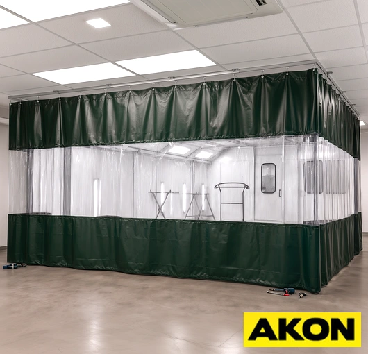 Industrial curtain track system installed in a paint booth to divide and contain spray painting areas.