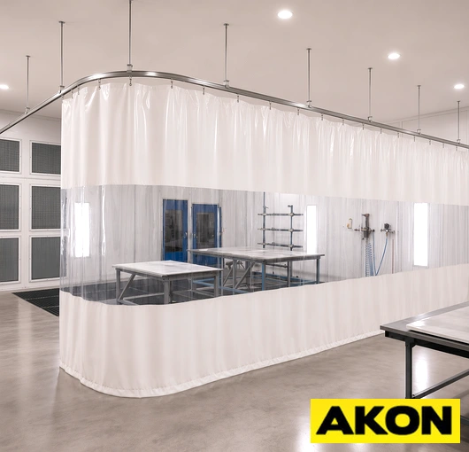 Heavy-duty curtain track system installed in an industrial paint booth to divide or enclose the spray area.