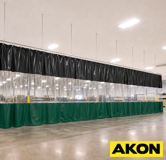 Industrial curtain track system installed overhead to divide a large facility into separate work zones.