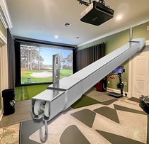 Home golf simulator room with a ceiling-mounted steel curtain track and roller hook